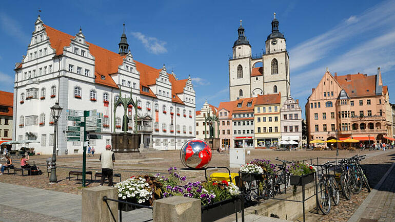 Marktplatz mit dem Alten Rathaus, Luther- und Melanchthondenkmal, Weltkugel sowie Blick auf die Türme der Stadtkirche St. Marien