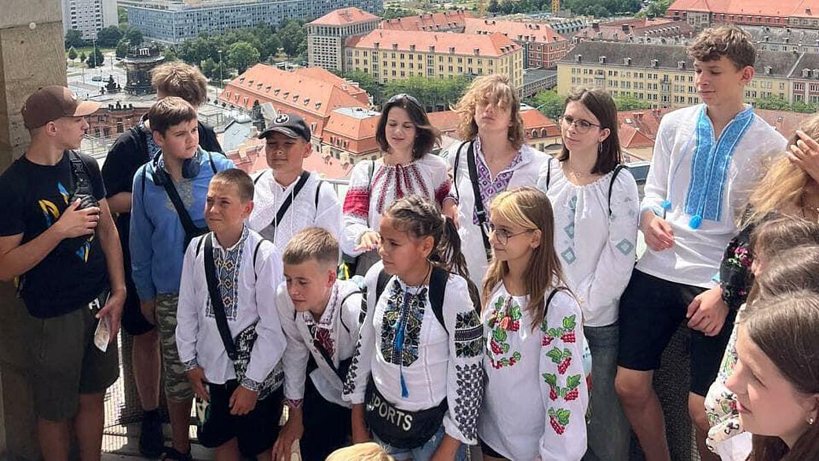 Eine Gruppe von Kindern steht vor dem Hintergrund der Dresdener Stadtkulisse