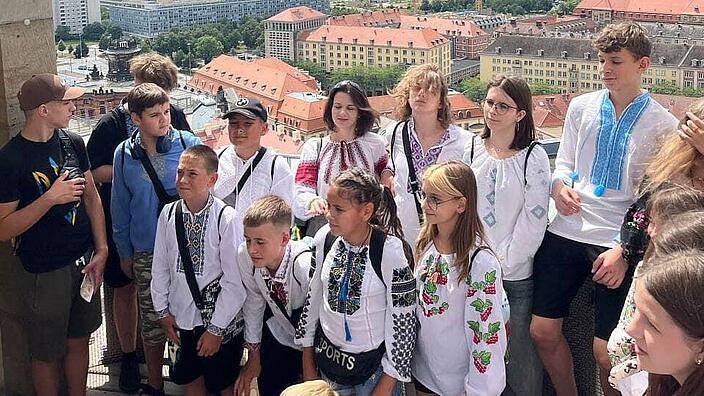 Eine Gruppe von Kindern steht vor dem Hintergrund der Dresdener Stadtkulisse