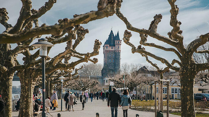 Rheinpromade mit dem Nibelungenturm im Hintergrund.