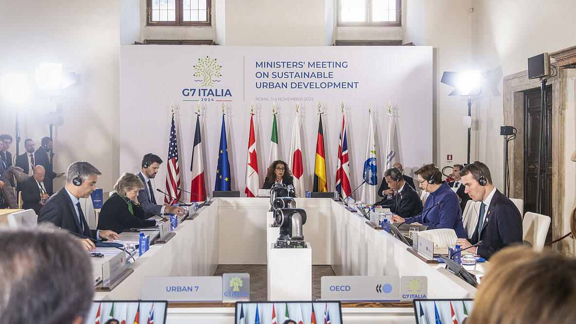 Ministerinnen und Minister des G7-Treffens für nachhaltige Stadtentwicklung in Rom sitzen an einem Konferenztisch